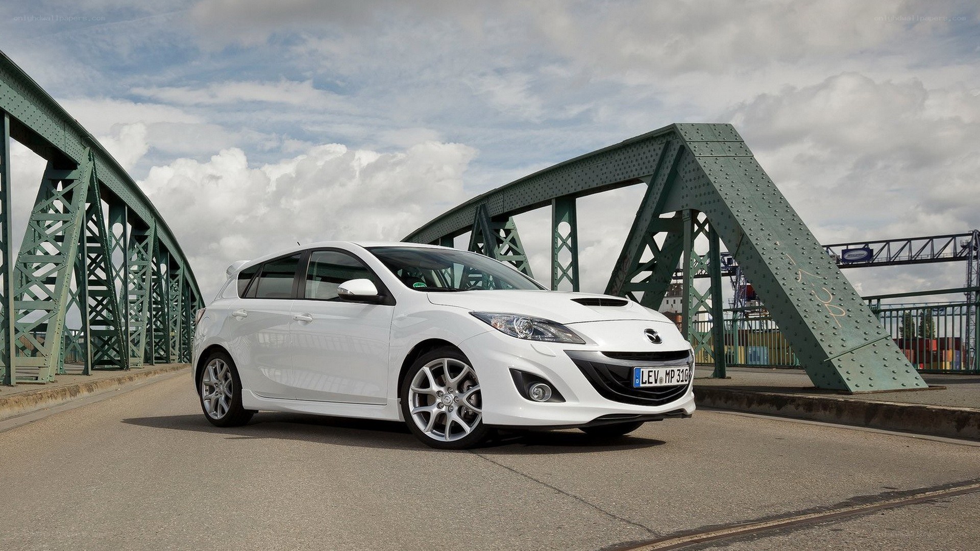 white mazda hatchback on a bridge