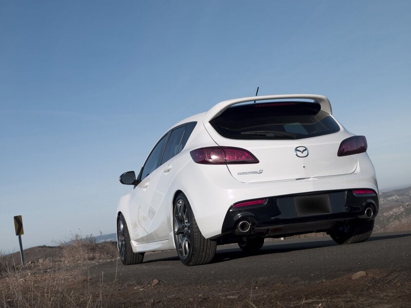 white mazda hatchback on road