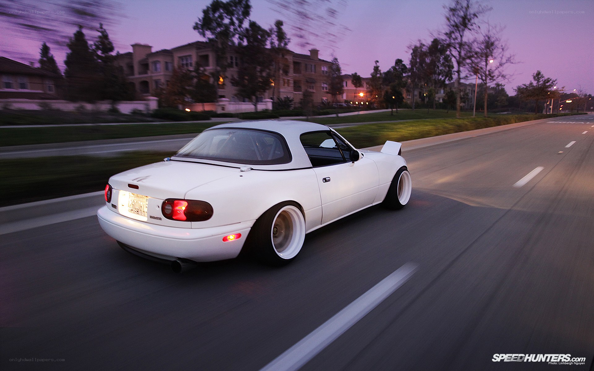 white mazda miata driving at dusk