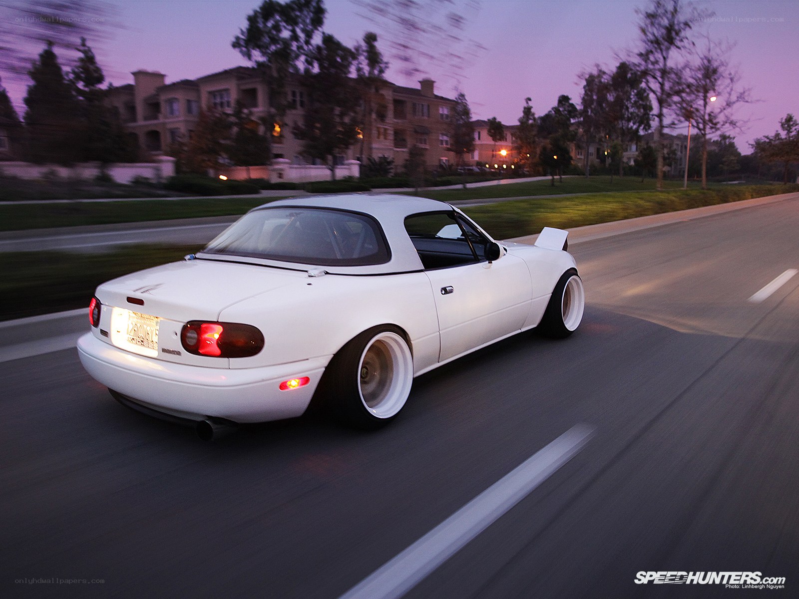 white mazda miata driving at dusk