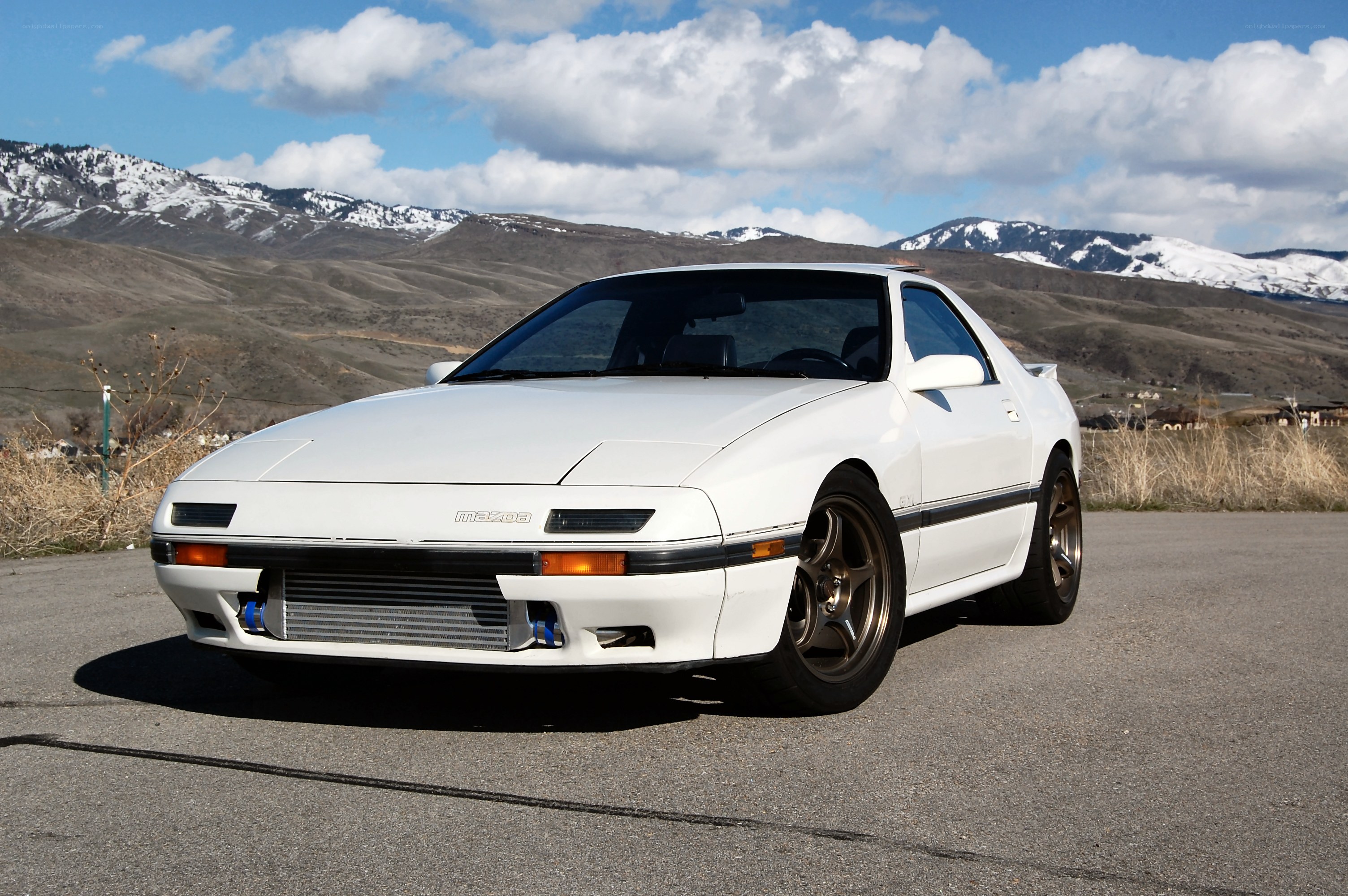 White Mazda RX-7 in mountain landscape