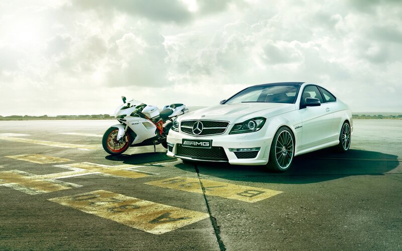 White Mercedes-AMG and Ducati motorcycle
