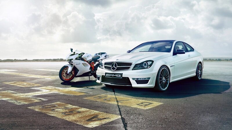 White Mercedes-AMG and motorcycle