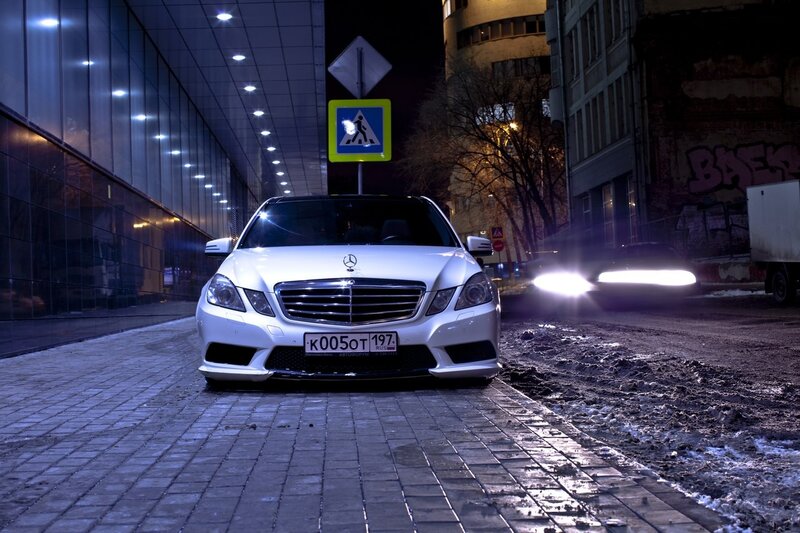 White Mercedes at night on cobblestones
