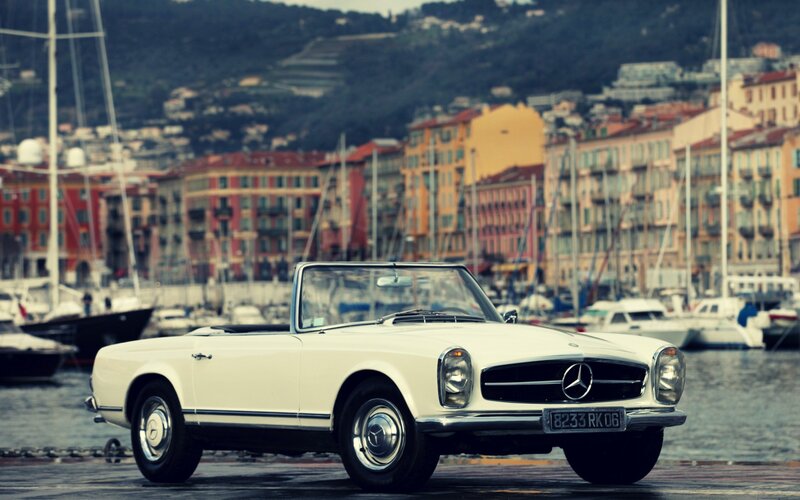 White Mercedes-Benz convertible by the harbor
