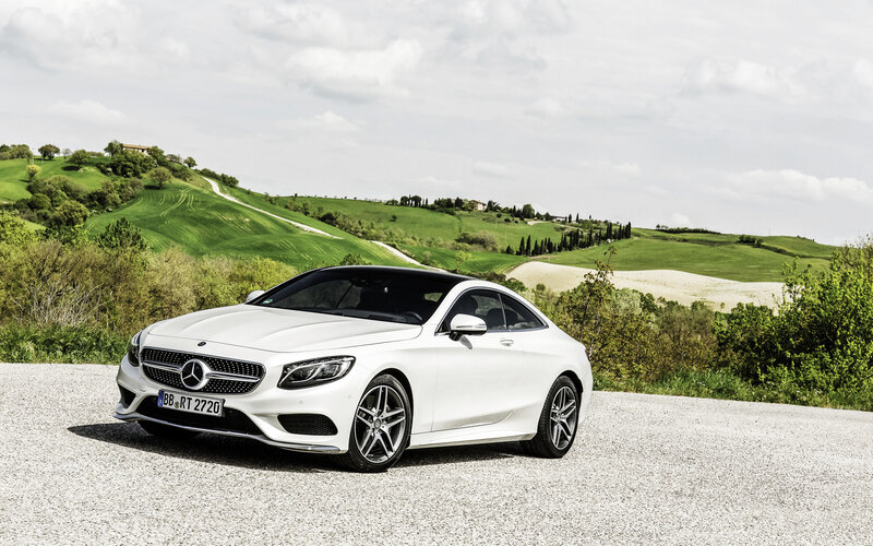 White Mercedes-Benz coupe on a scenic road