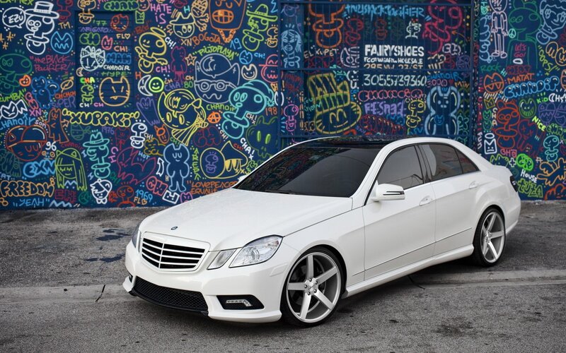 White Mercedes-Benz in front of graffiti wall
