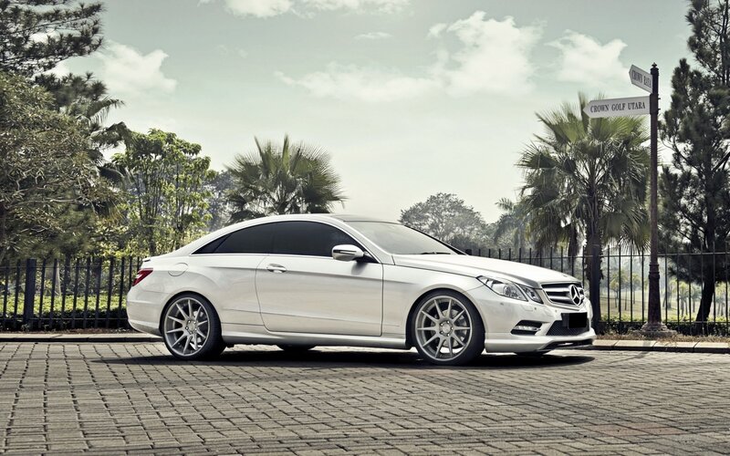 White Mercedes-Benz parked on cobblestone