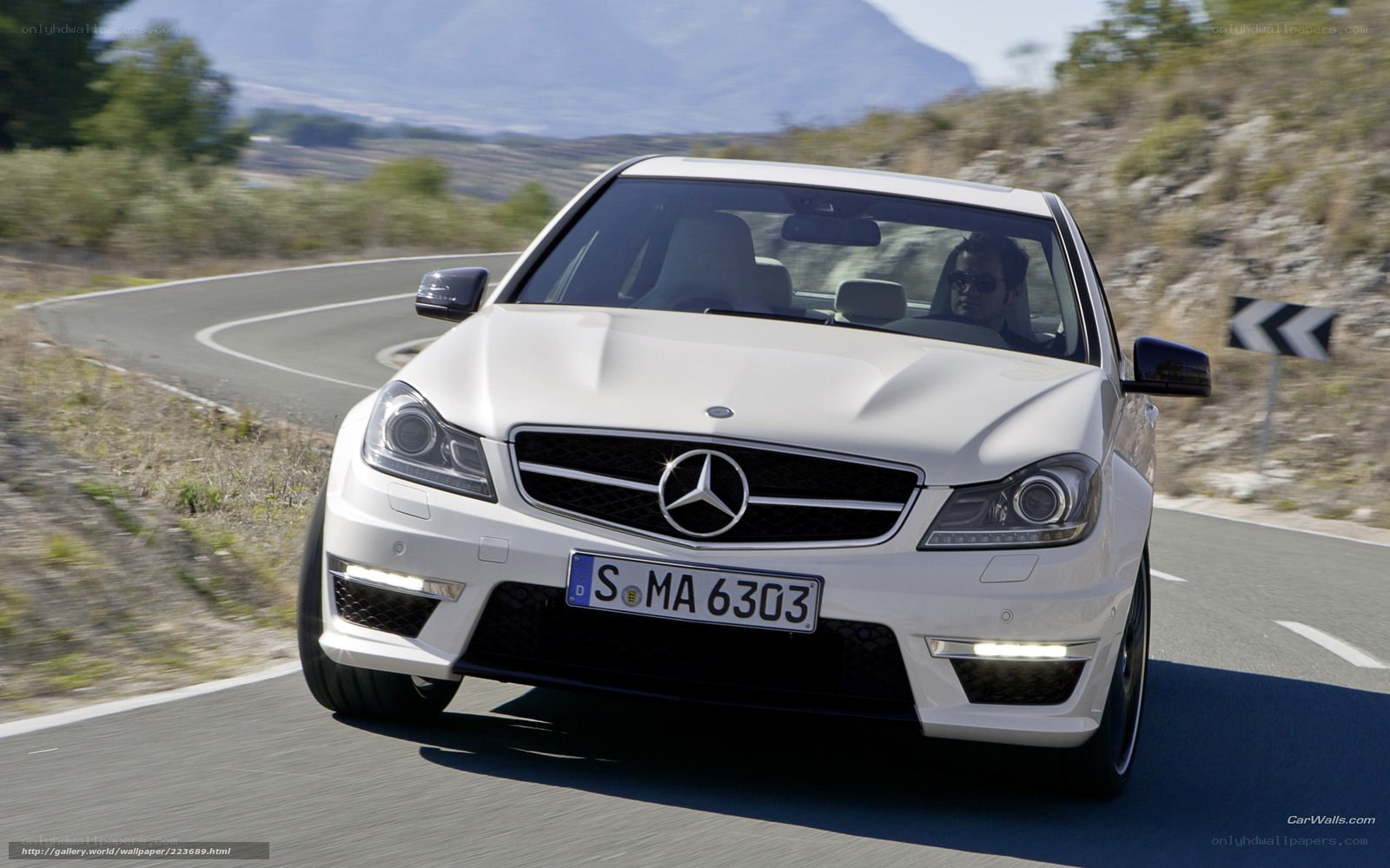 white mercedes c63 amg on winding road