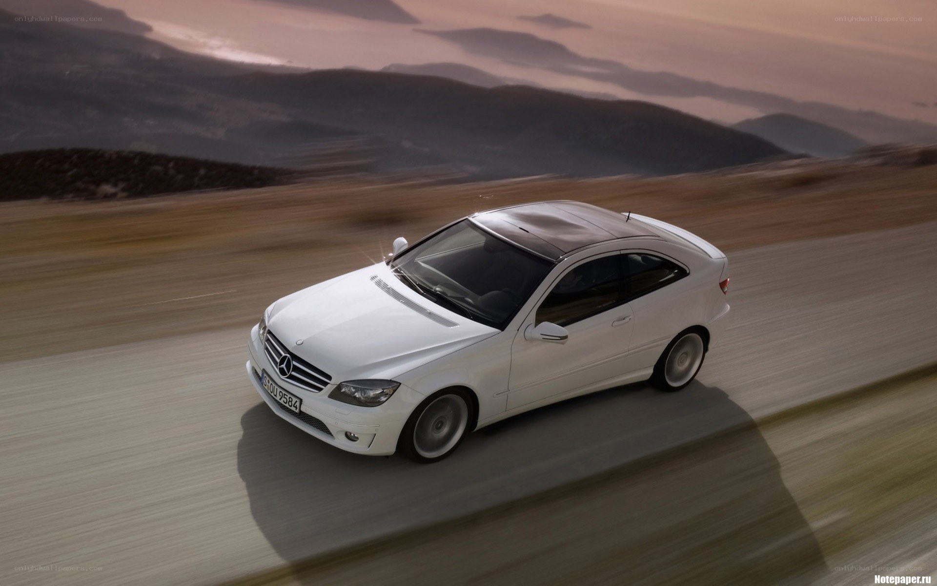 white mercedes driving on road
