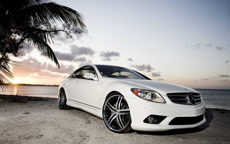 White Mercedes on beach at sunset