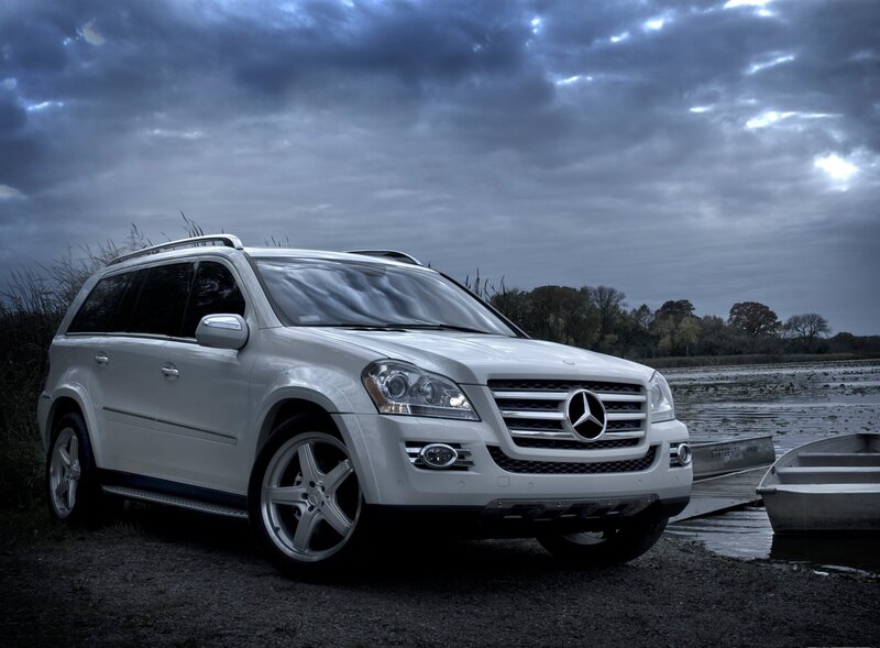 White Mercedes SUV by a lake