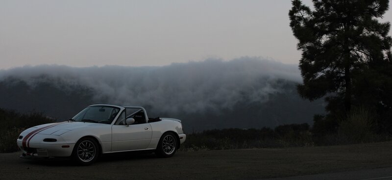 White Miata on a foggy hillside