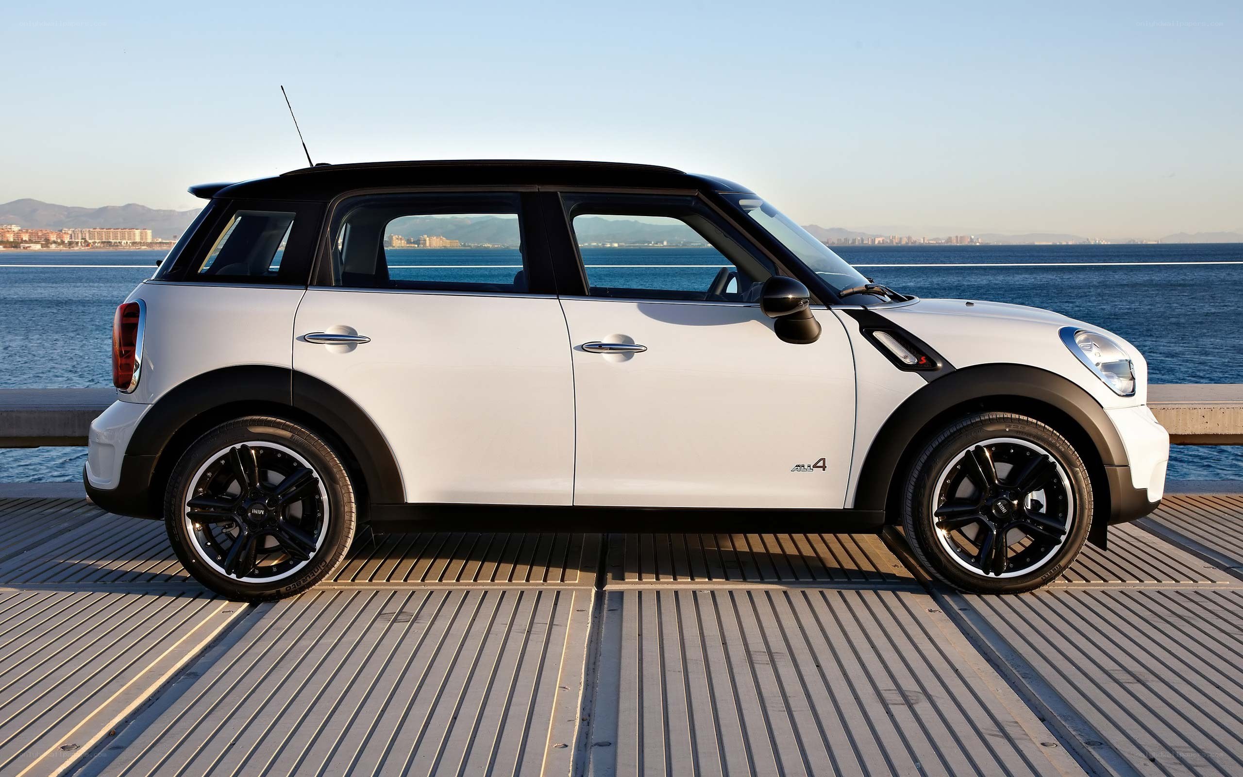 white mini cooper parked by the sea