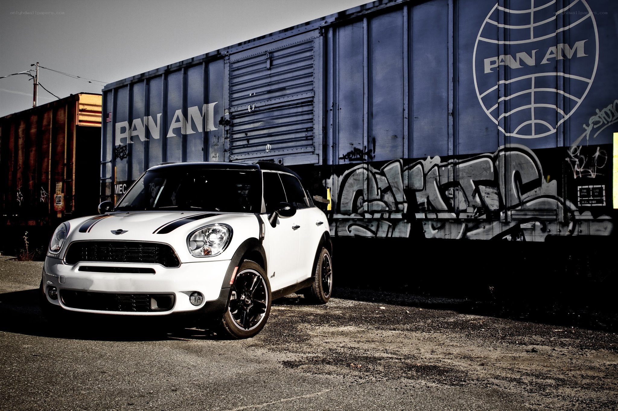 White Mini Cooper parked by train