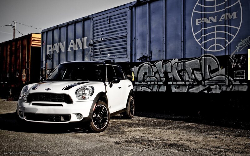 White Mini Cooper parked by train