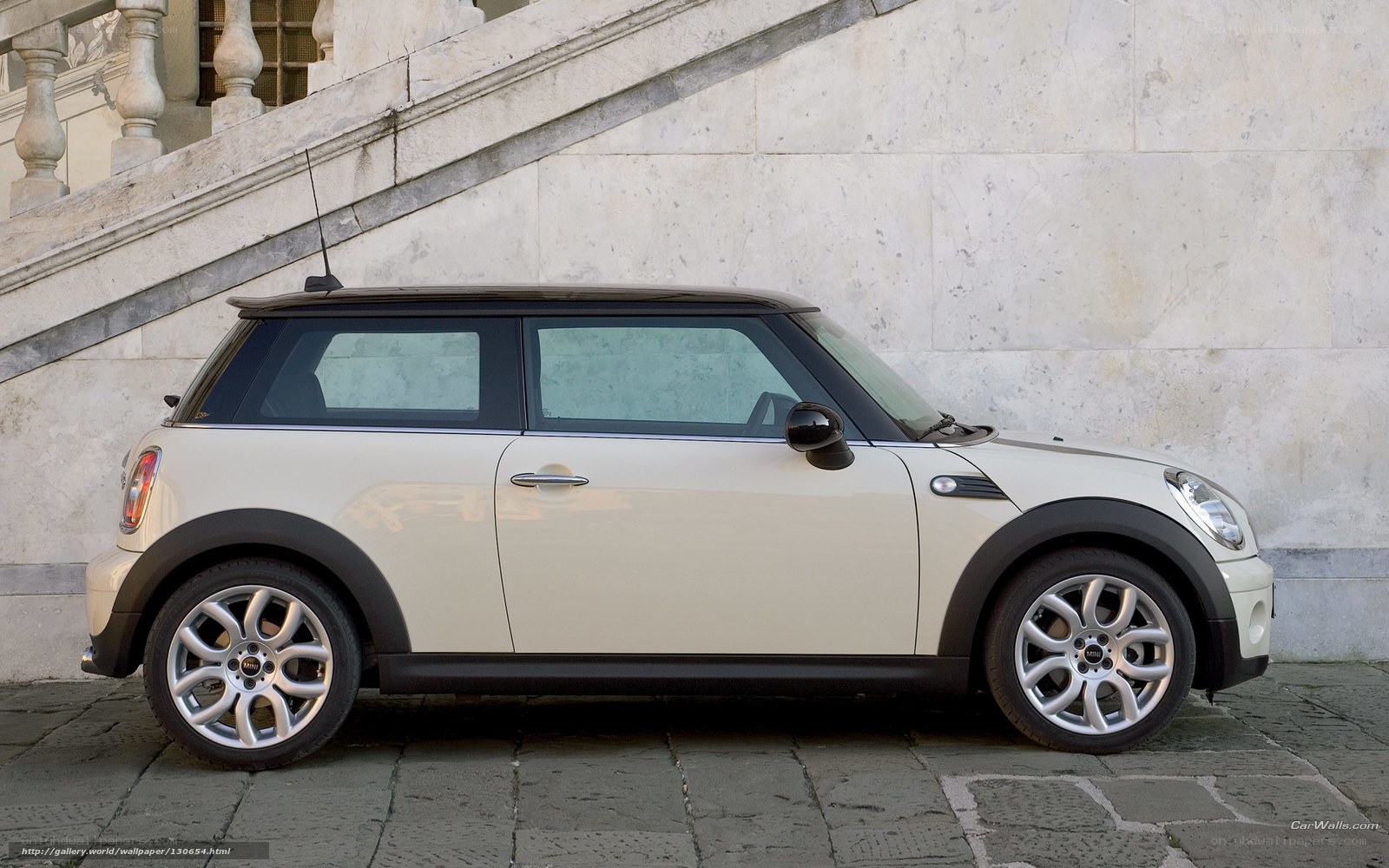 White Mini Cooper parked on cobblestones