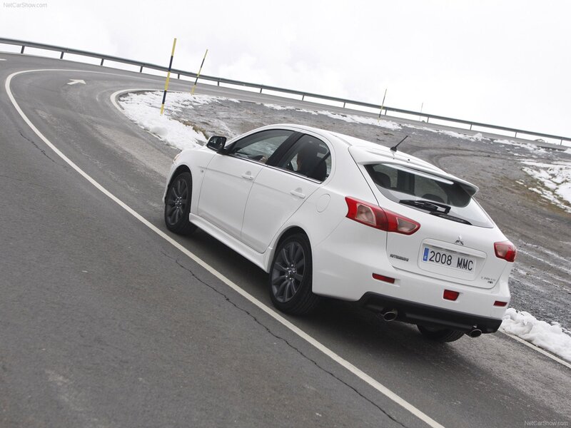 White Mitsubishi Lancer driving on a mountain road