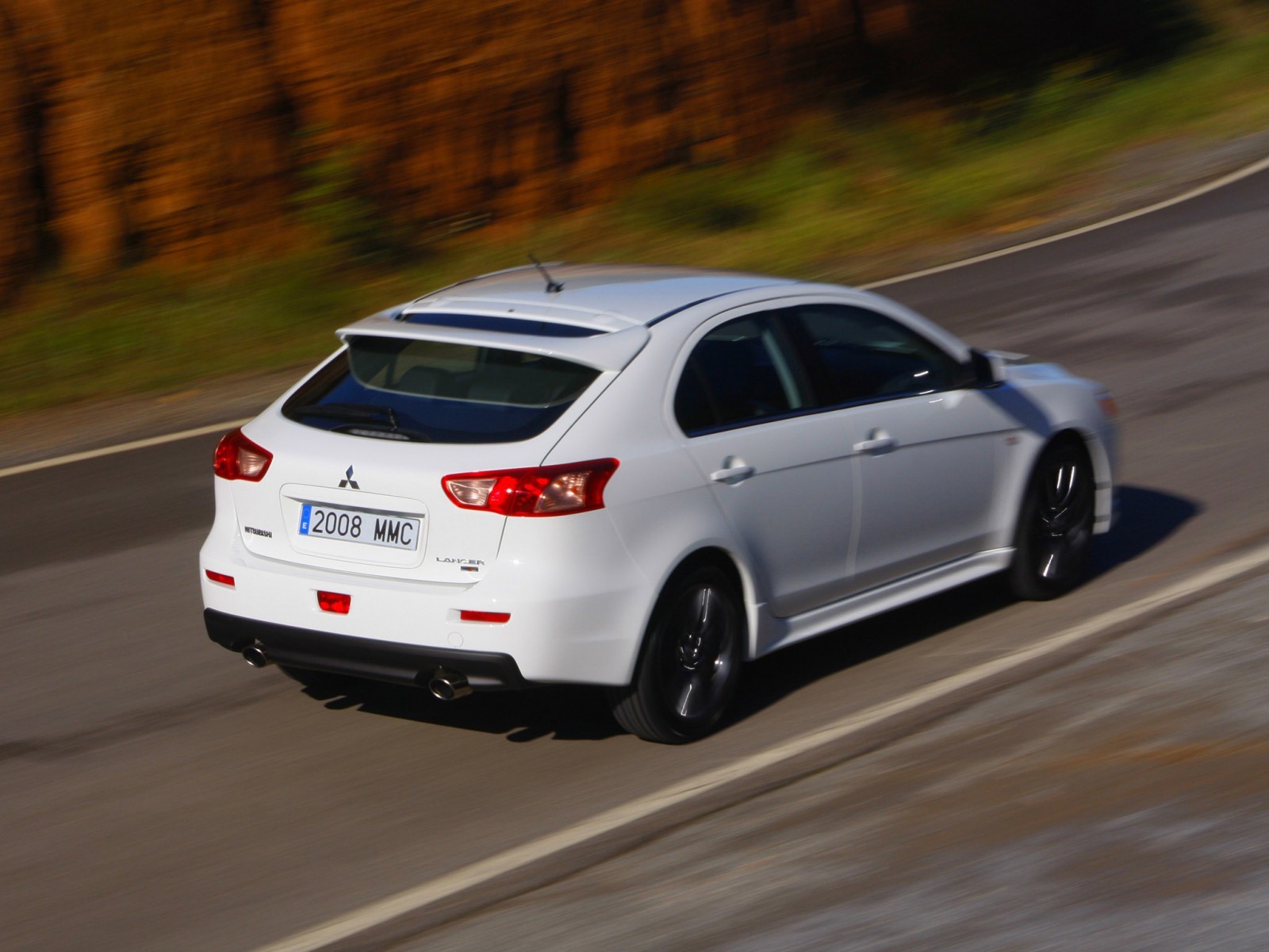 white mitsubishi lancer driving