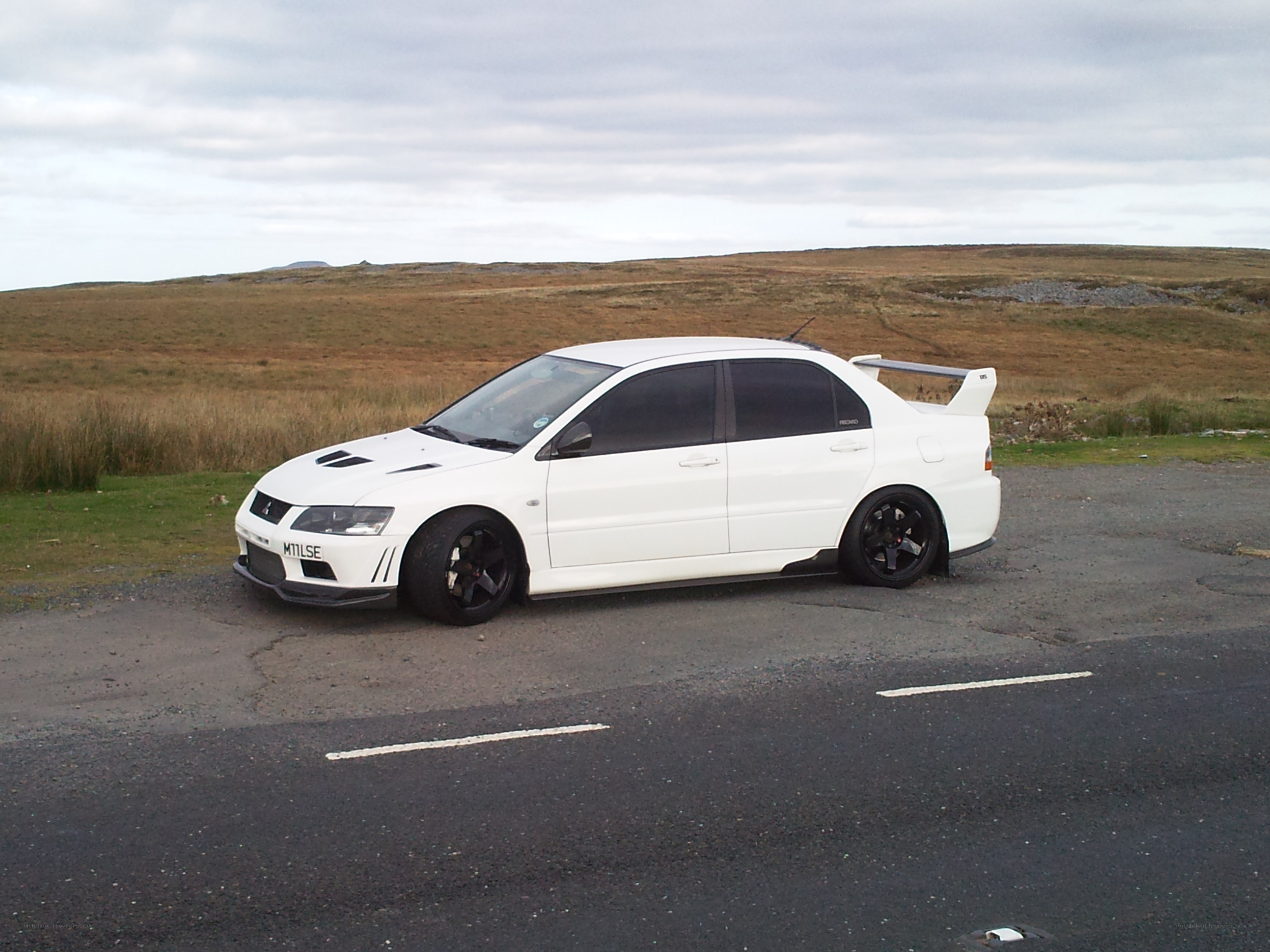 white mitsubishi lancer evo parked