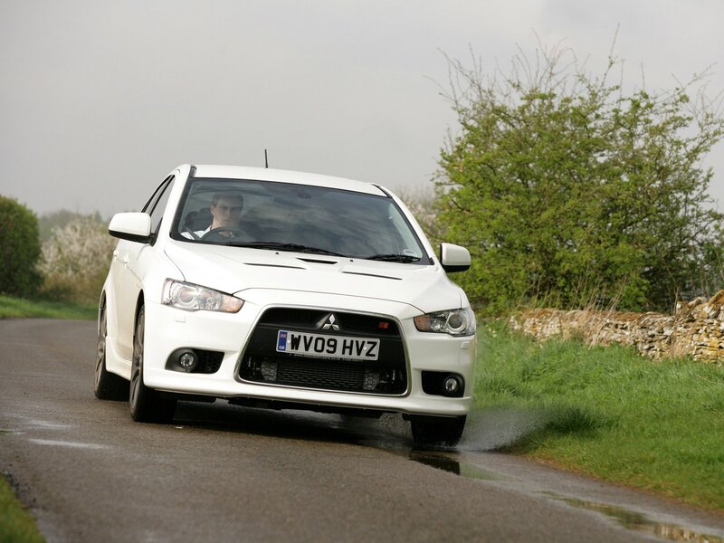 white mitsubishi lancer evolution driving