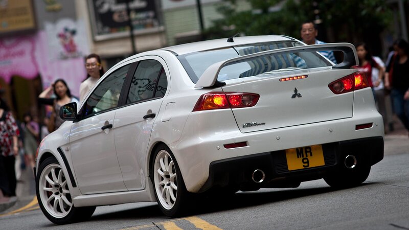 white mitsubishi lancer evolution on city street