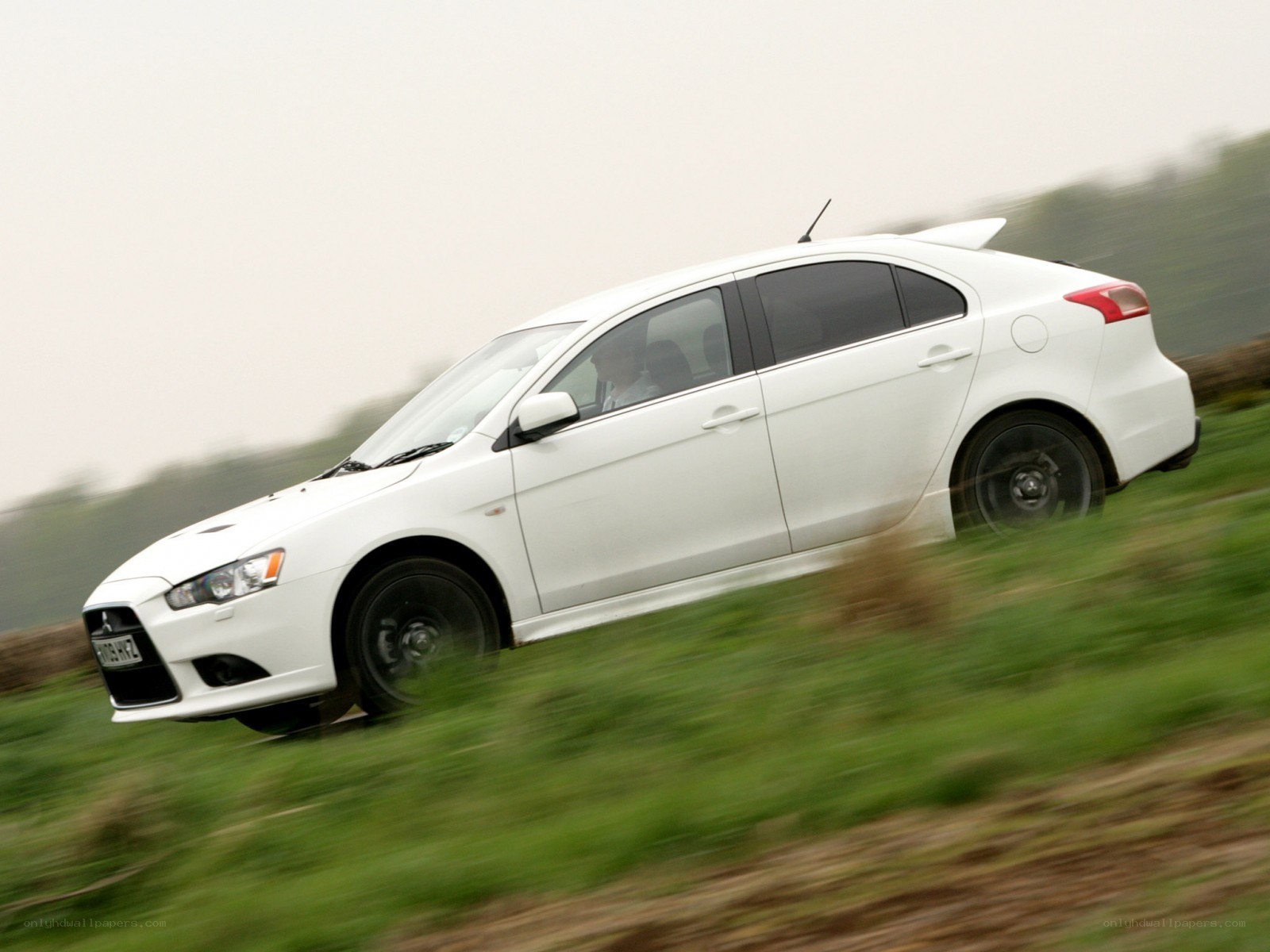 white mitsubishi lancer in motion
