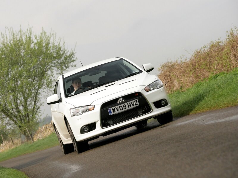 white mitsubishi on country road