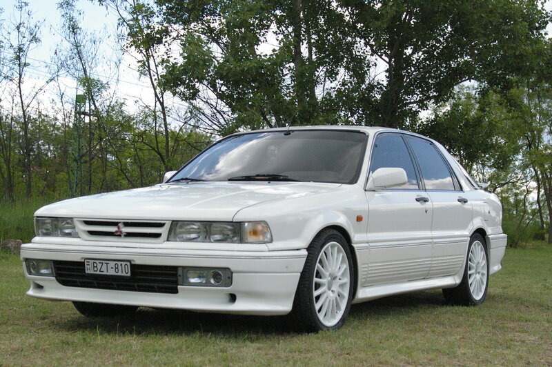 white mitsubishi sedan on grass