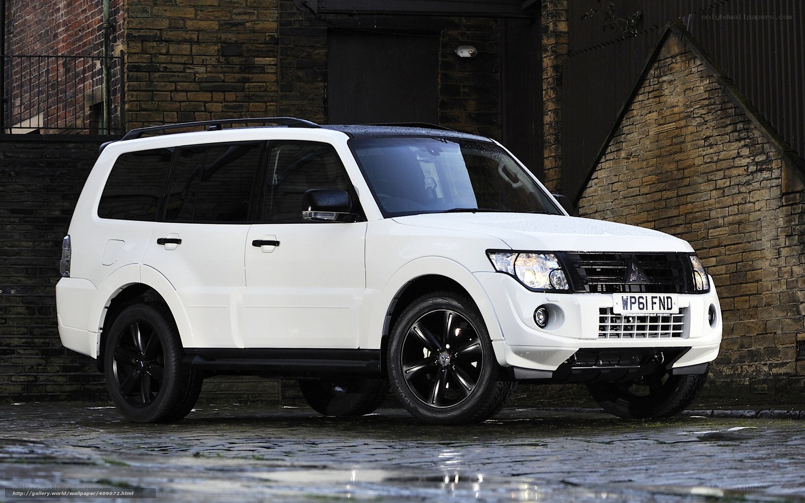 white mitsubishi suv on cobblestones