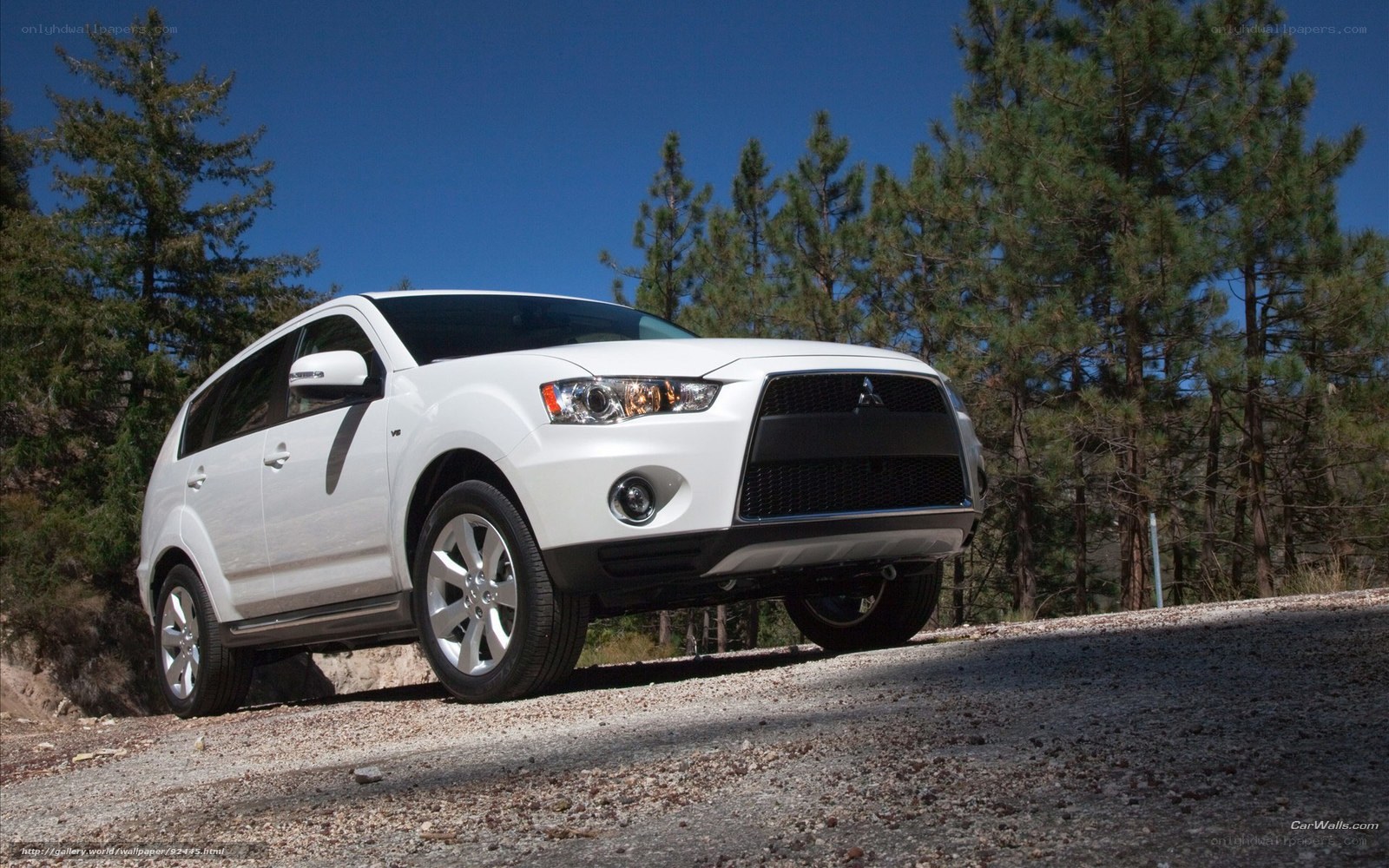 White Mitsubishi SUV on gravel road