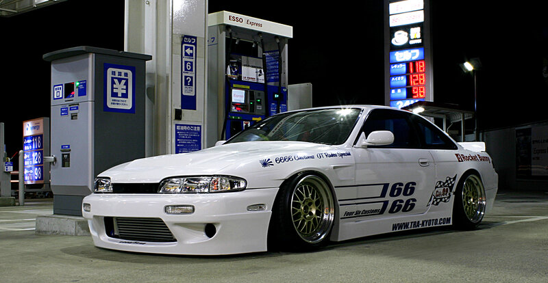 white modified coupe at gas station