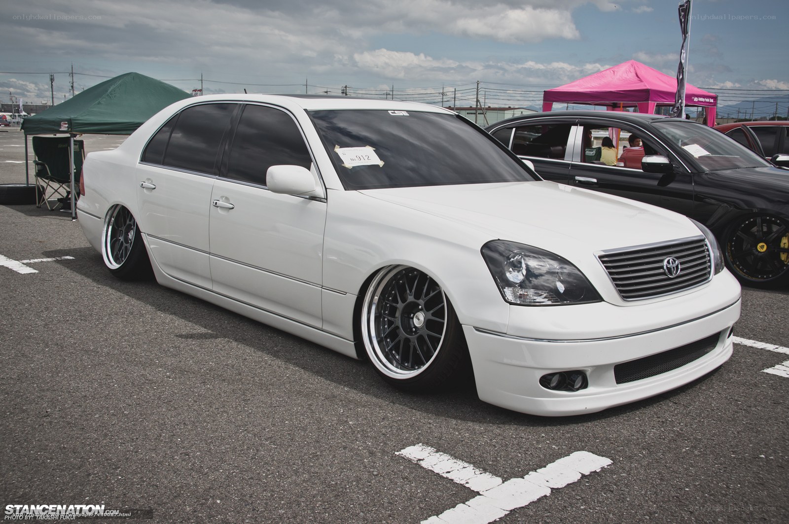 white modified sedan at car show