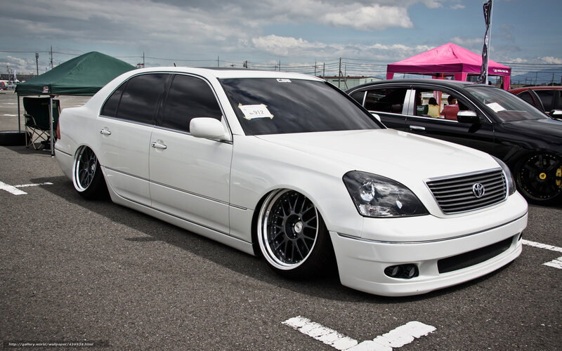 white modified sedan at car show