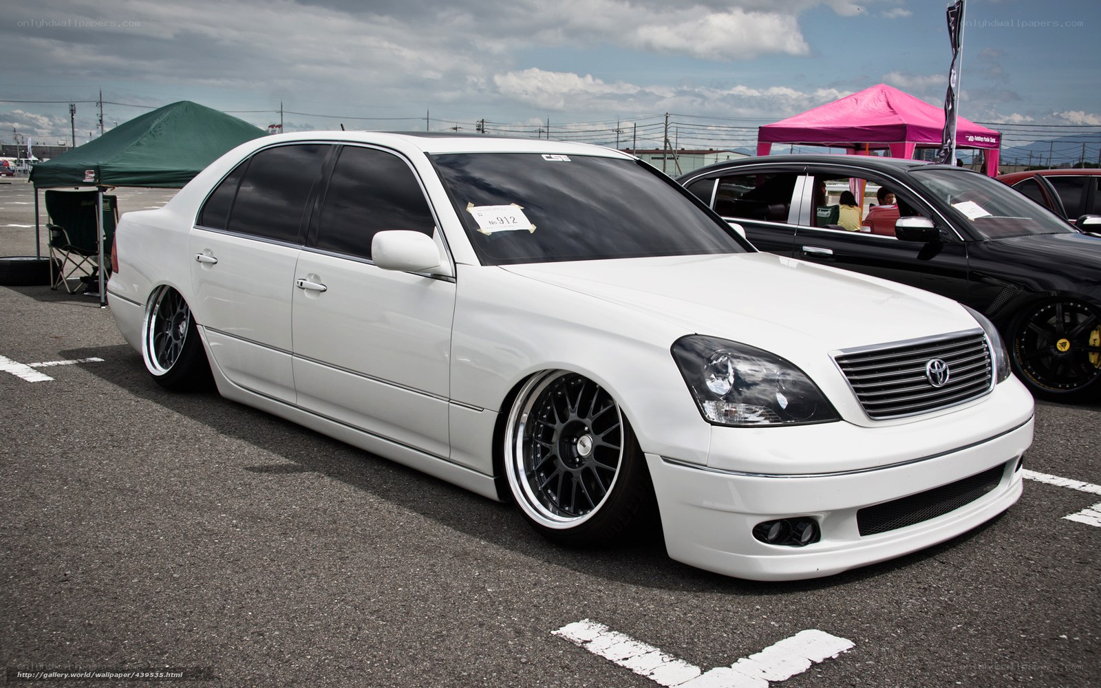 white modified sedan at car show