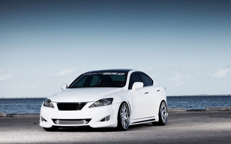 white modified sedan by the water