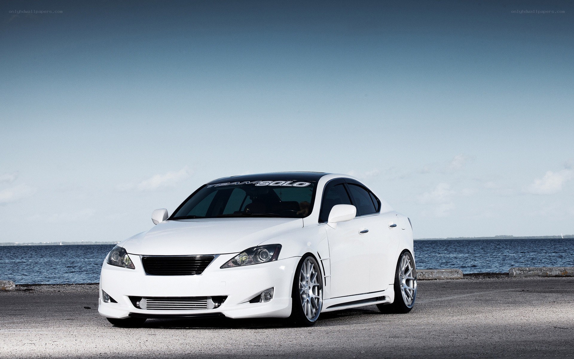 white modified sedan by the water