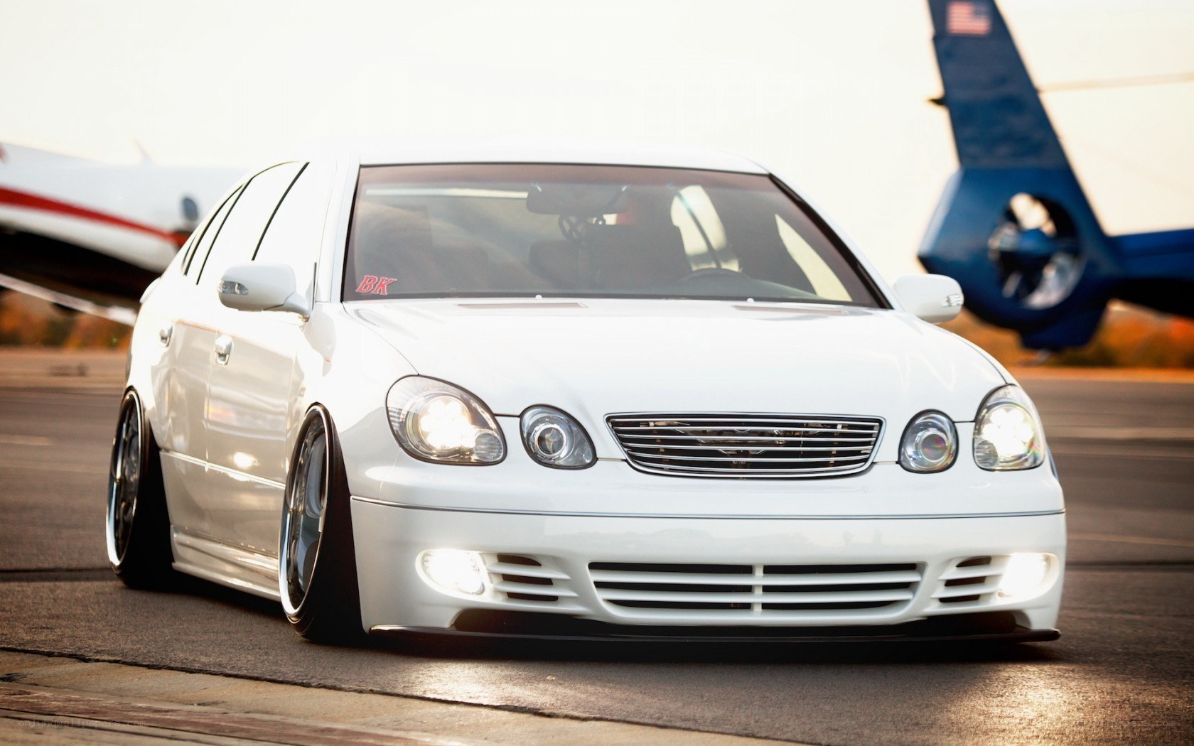white modified sedan on tarmac