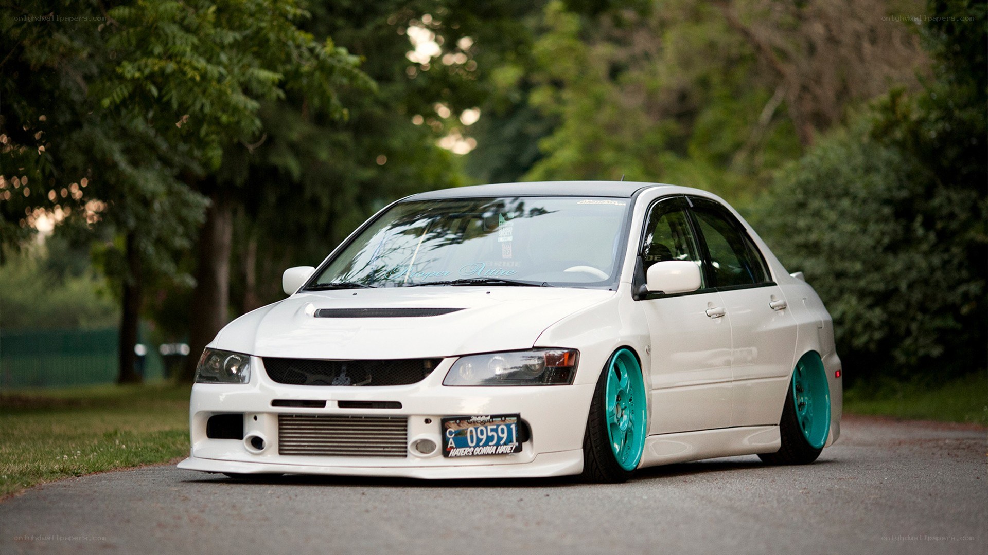 white modified sedan with teal wheels