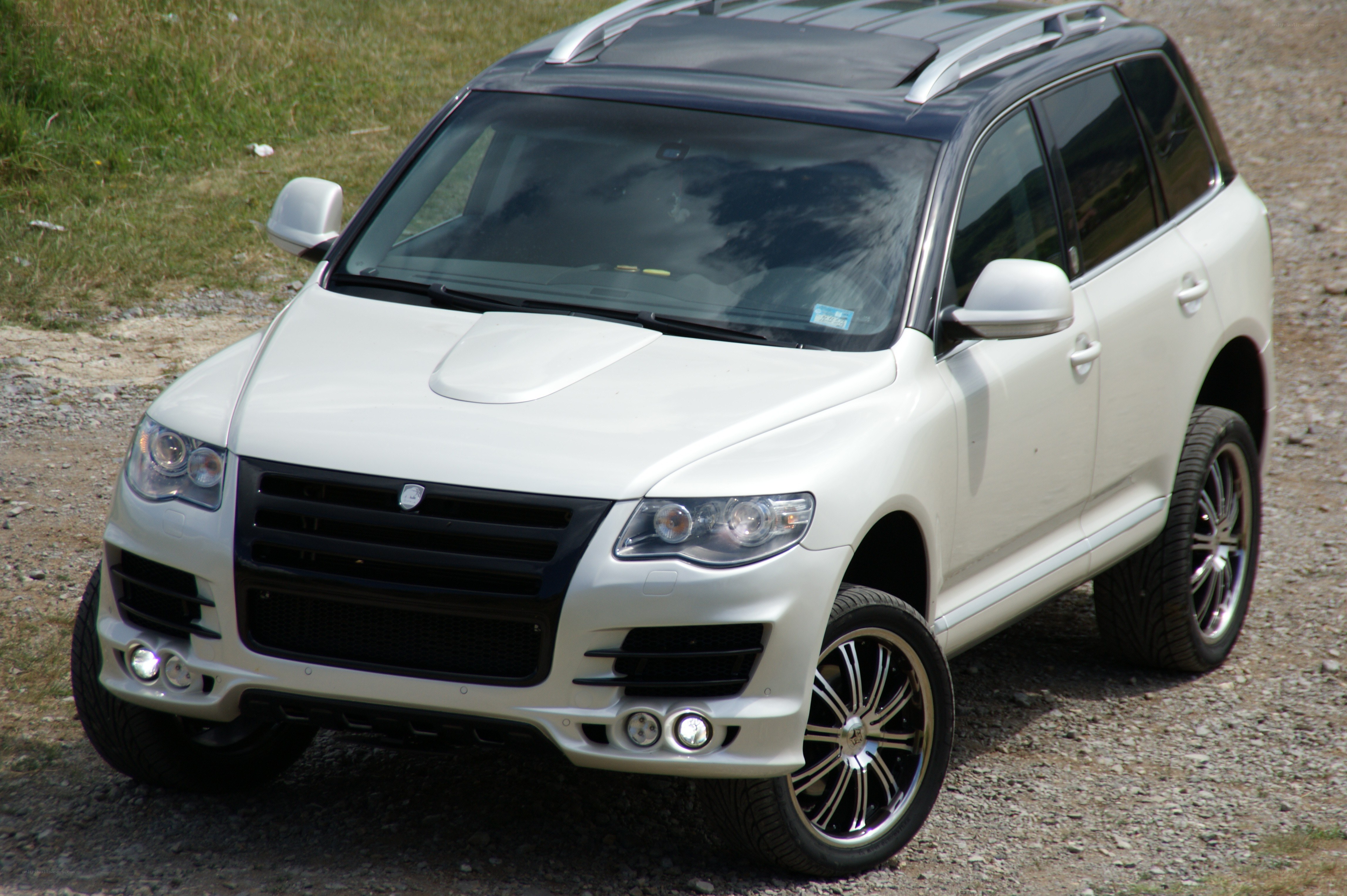 white modified suv on gravel