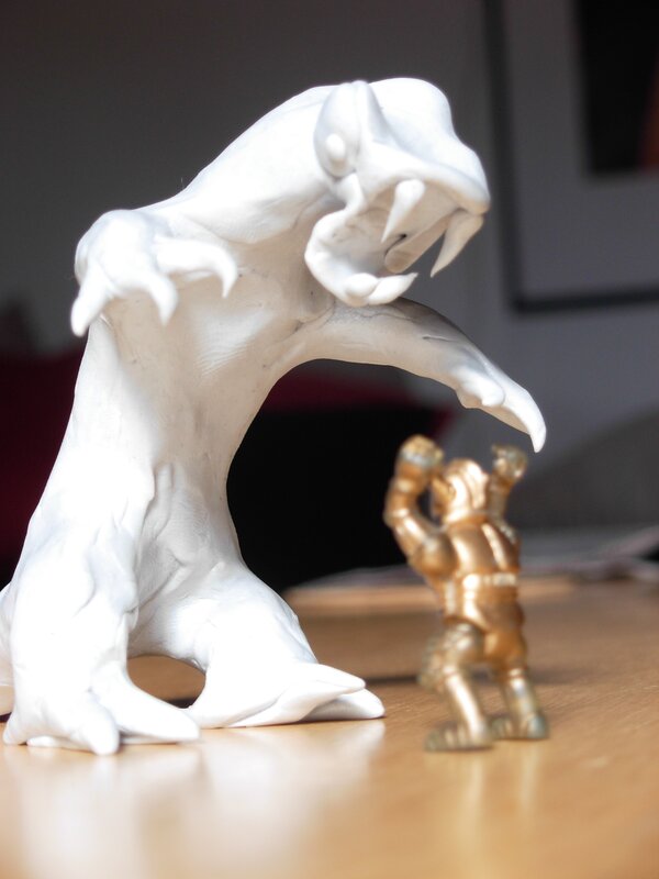 White monster figurine with golden warrior