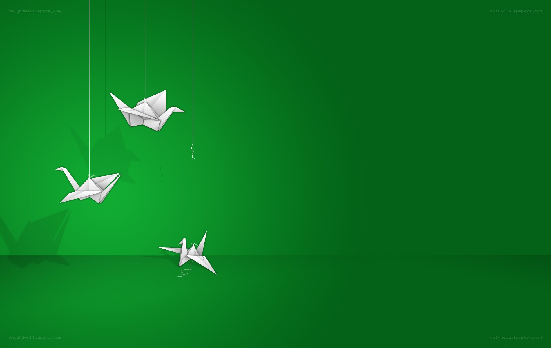 White origami cranes on green
