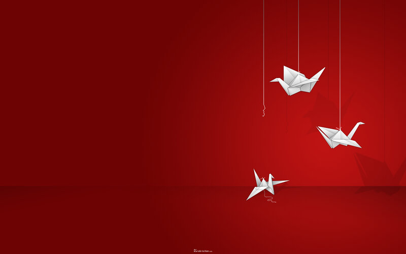 White origami cranes on red