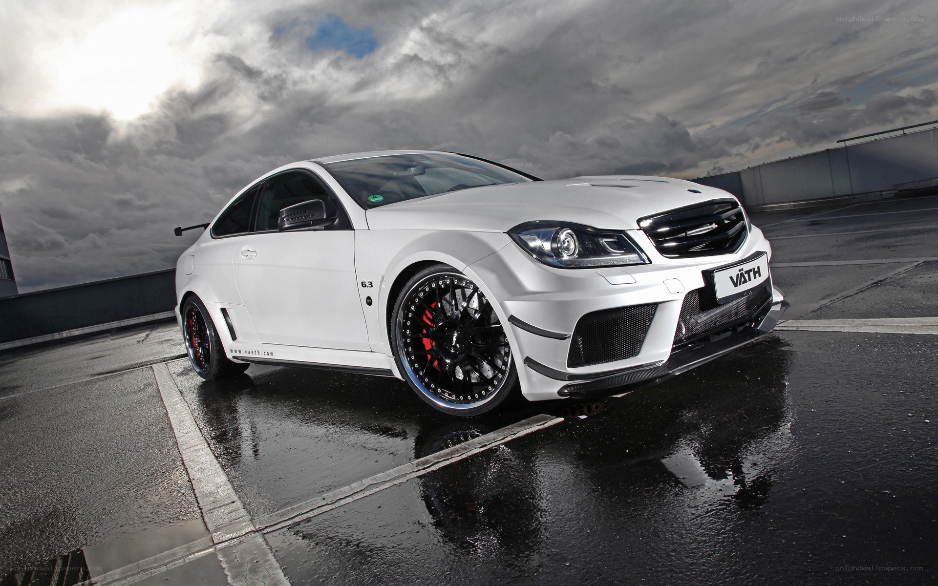 white performance coupe on wet pavement
