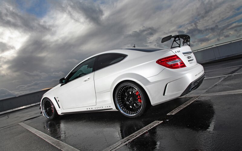 white performance coupe on wet road