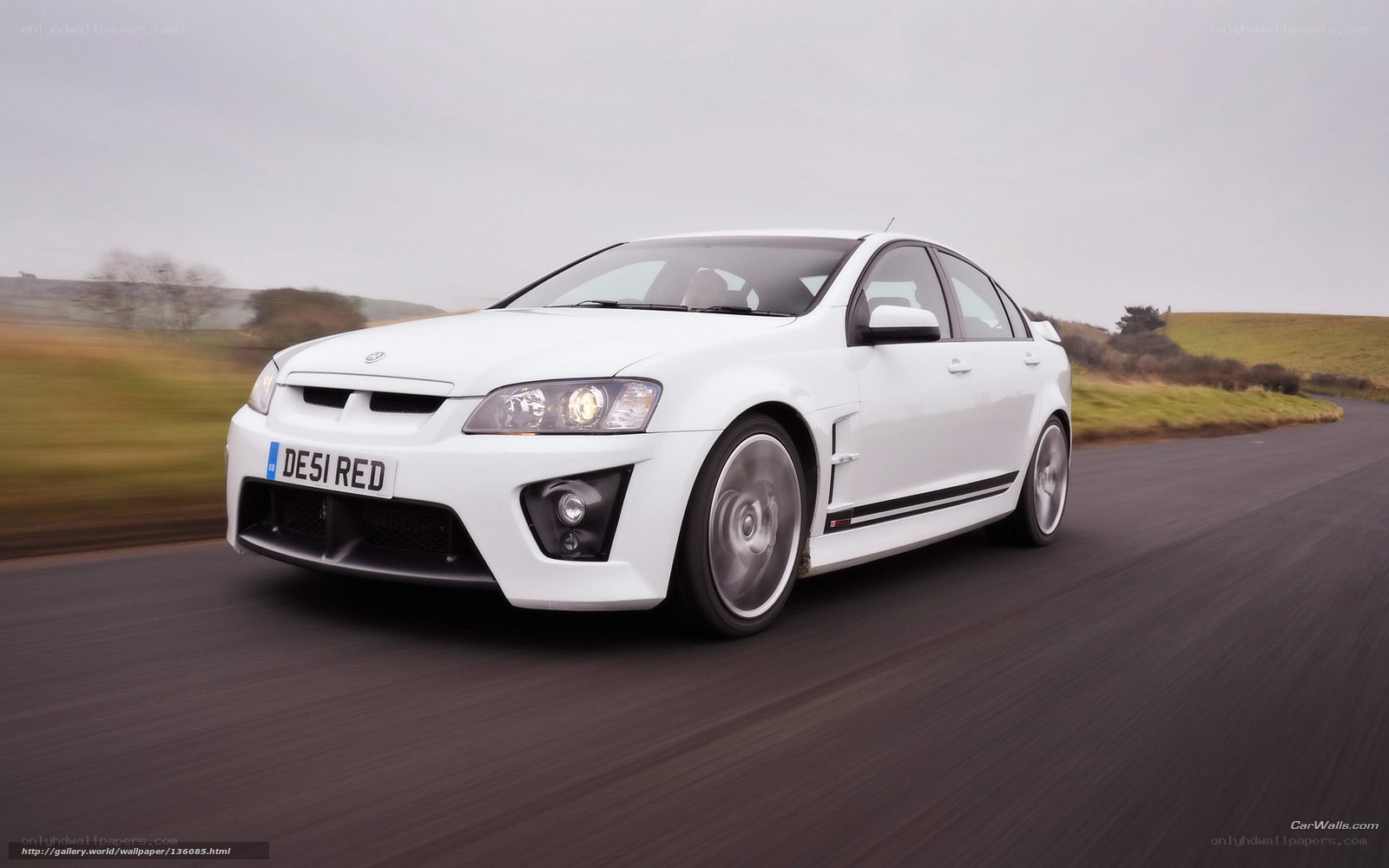 white performance sedan on road