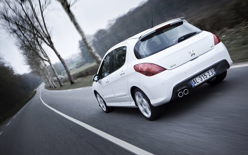 white peugeot 308 driving on road