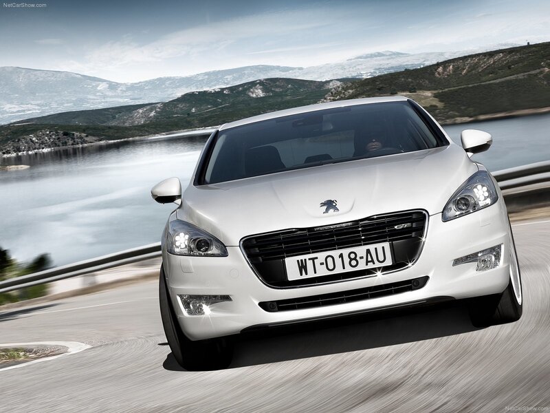 White Peugeot 508 GT driving on a scenic road