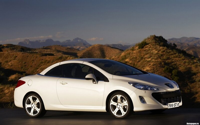 white peugeot coupe on mountain road