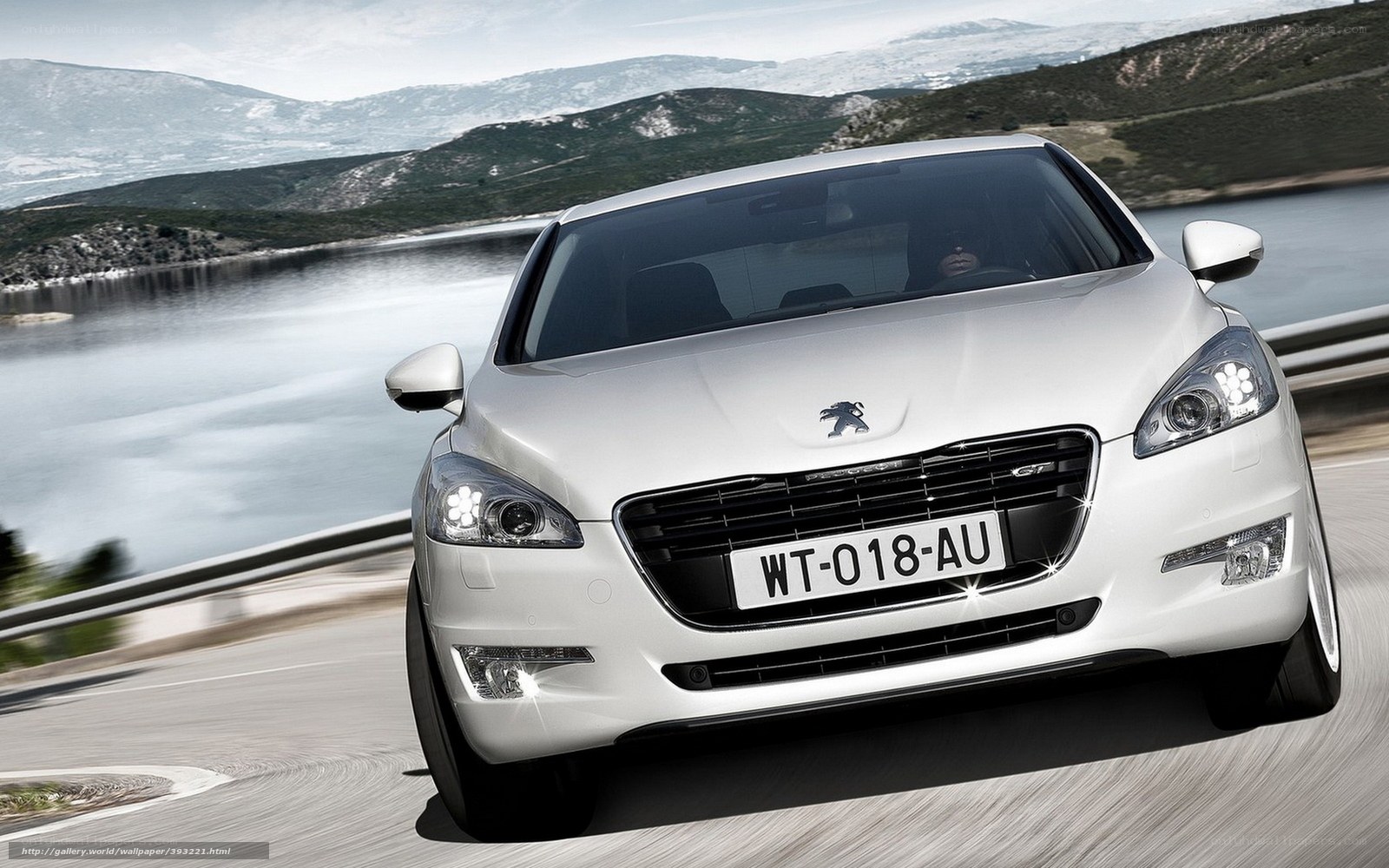 White Peugeot driving on a scenic road